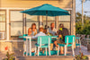 A Family sitting at the surfboard table eating dinner on the patio. They are sitting in matching chairs.