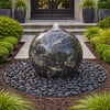 Decorative spherical water feature in a garden setting with plants and steps in the background.