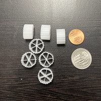 Wagon Wheel shaped media for pressure filter. Displayed next to a penny and a quarter for size reference.