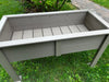 Inside of a Gray outdoor raised planter box on a grassy area