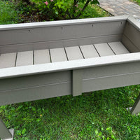 Inside of a Gray outdoor raised planter box on a grassy area