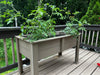 Raised garden poly planter box with plants on a wooden deck