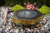 Fountain in a garden with pebbles and plants