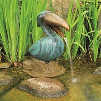 Aquascape® Toucan Spitter placed beside shallow area of pond